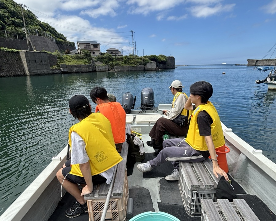 足元がフラットな船に腰掛けて海へ向かう参加者