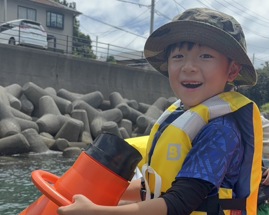 箱メガネで海の中を覗き込むお子さま